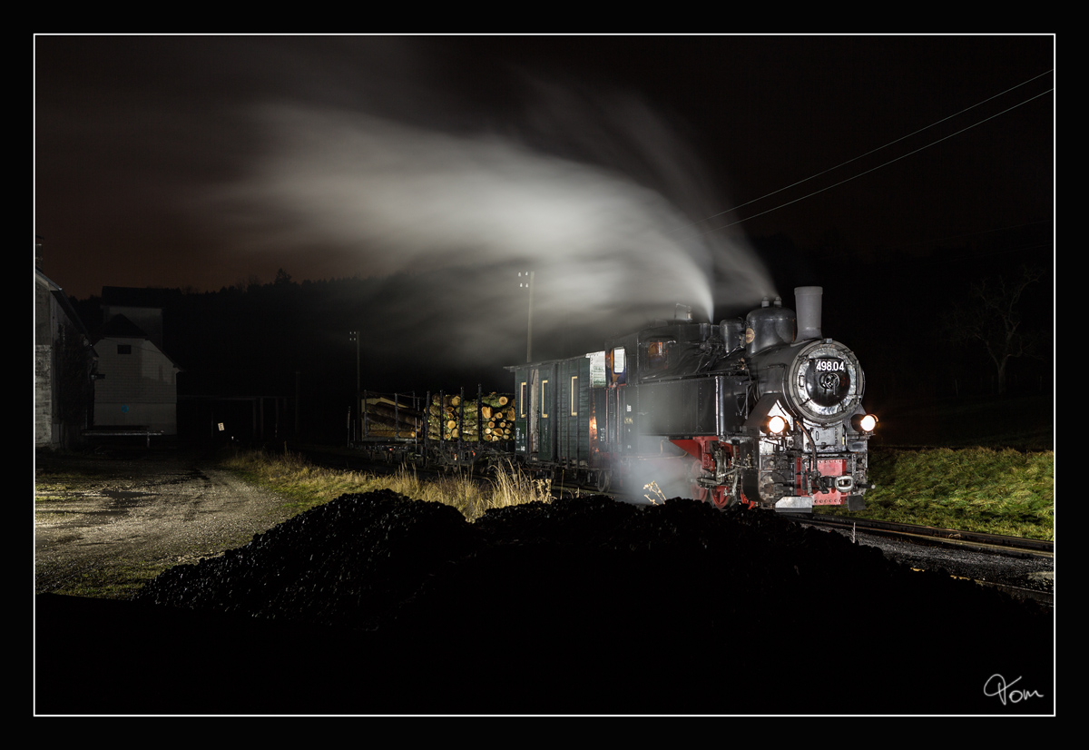 Through the dark night III - Die ÖGEG Dampflok 498.04 steht mit einem Holzzug in der Haltestelle Sommerhubermühle. 04.01.2018