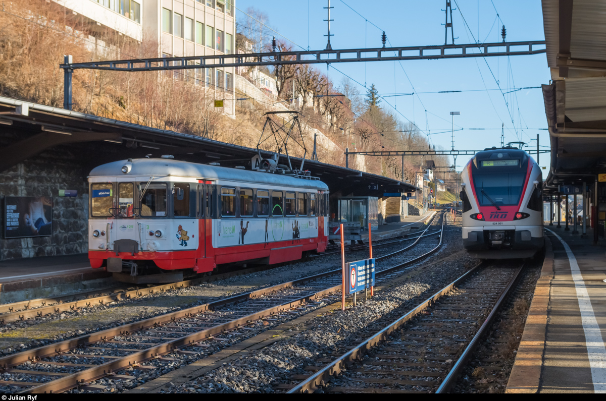 TILO flirtet jetzt auch im Neuenburger Jura: Derzeit weilen zwei TILO-FLIRT in der Region, welche vorwiegend zwischen Neuchâtel und Le Locle eingesetzt werden. Am 22. Dezember 2015 wartet der RABe 524 001 im Bahnhof Le Locle auf die Abfahrt als Regio nach La Chaux-de-Fonds. Auf dem andern Gleis steht der BDe 4/4 3, der gerade aus Les Brenets eingetroffen ist.
