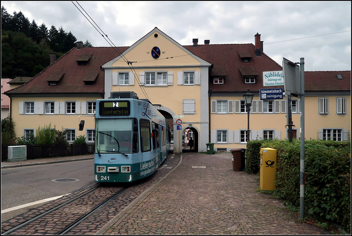 Tordurchfahrt in Freiburg-Günterstal -

Wohl die Standardansicht der Situation. 

Unerwarteter Weise hat ich mit ein mir bisher nicht passierten Störung in der Straßenbahnfotografie zu tun. Es war der Tag der Müllabfuhr und so standen an zahlreichen Stellen entlang der Strecke Mülleimer an der Straße, was das schöne Ortsbild doch empfindlich stört. Meine Motivwahl war dadurch leider eingeschränkt.

07.10.2019 (M)