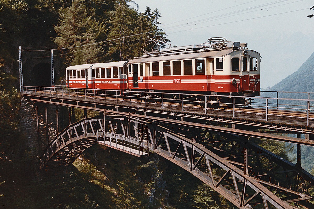 TPC/ASD: 100  Jahre ASD. Ueber das kommende Wochenende feiert die ASD ihren 100. Geburtstag. Zu diesem Anlass wird der restaurierte BCFe 4/4 1 im grau-weissen Anstrich mit Nostalgiezügen im Einsatz stehen. ABDe 4/4 2 mit zwei AOMC B2 auf der Vanelbrücke im Juli 1984.
Foto: Walter Ruetsch