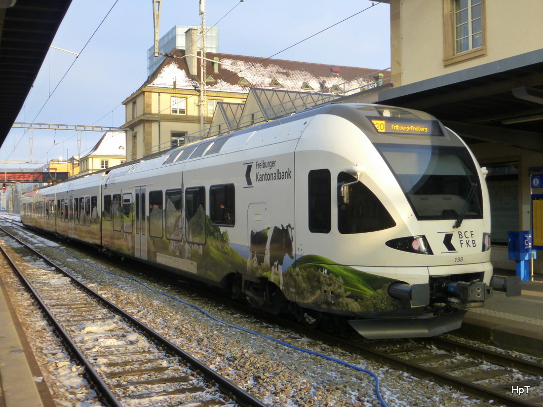 tpf - Werbe Triebzug RABe 527 198-1 als S20 nach Fribourg im Bahnhof Neuchâtel am 07.02.2015