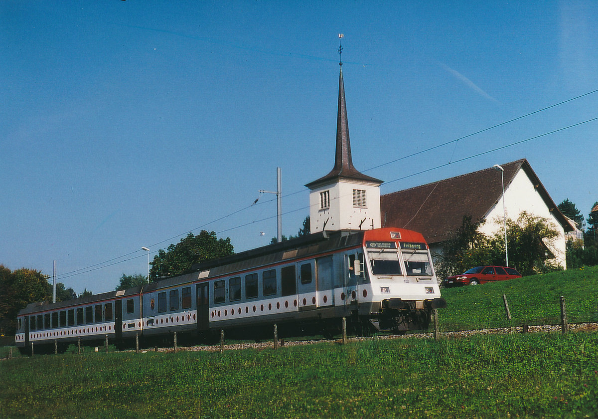TPF/GFM: Regionalzug nach Fribourg mit dem RABDe 4/4 182 mit Baujahr 1991, bei Courtepin im Oktober 1999.
Foto: Walter Ruetsch