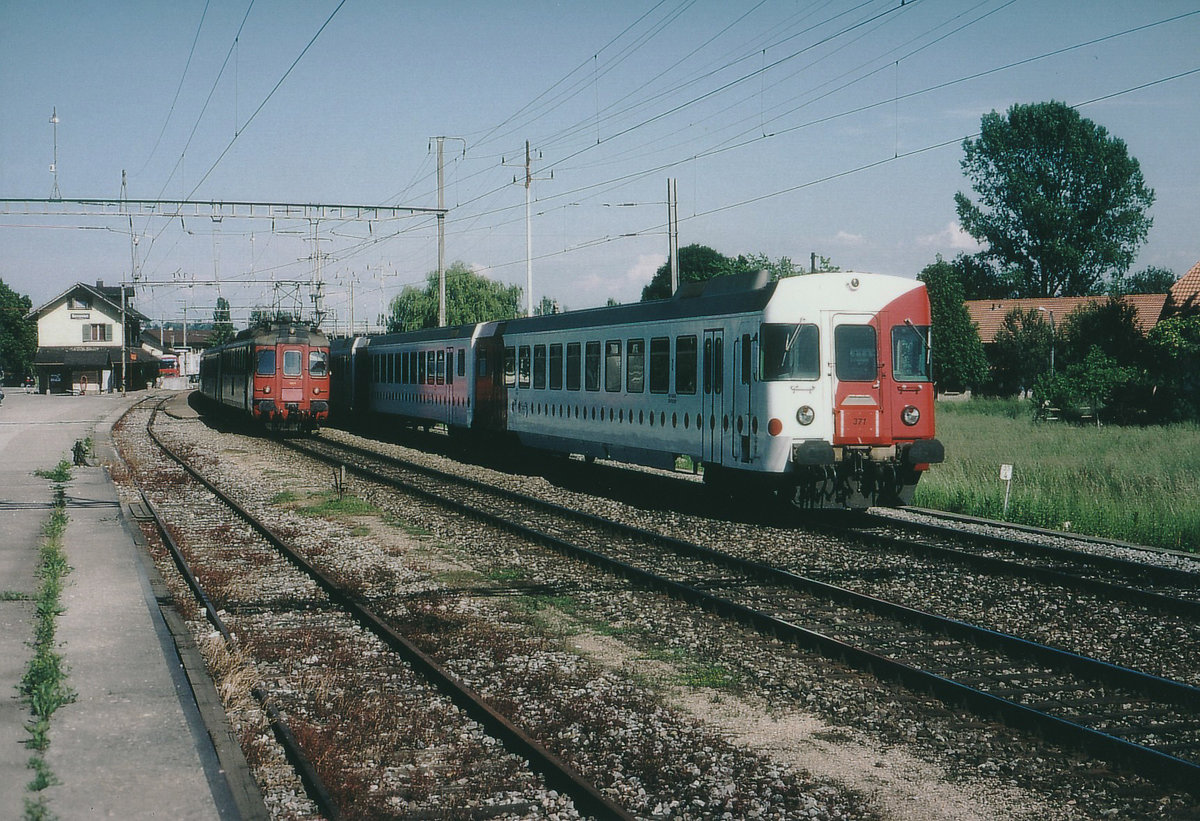 TPF/SBB: Einmalige Zugskreuzung auf der TPF-Station Sugiez, wo normalerweise keine Zugskreuzungen stattfanden, zwischen einem TPF-RBDe 567-Pendel mit dem ABt 371 und einem SBB-RBe 4/4-Pendel mit altem Anstrich im Juni 2002.
Foto: Walter Ruetsch