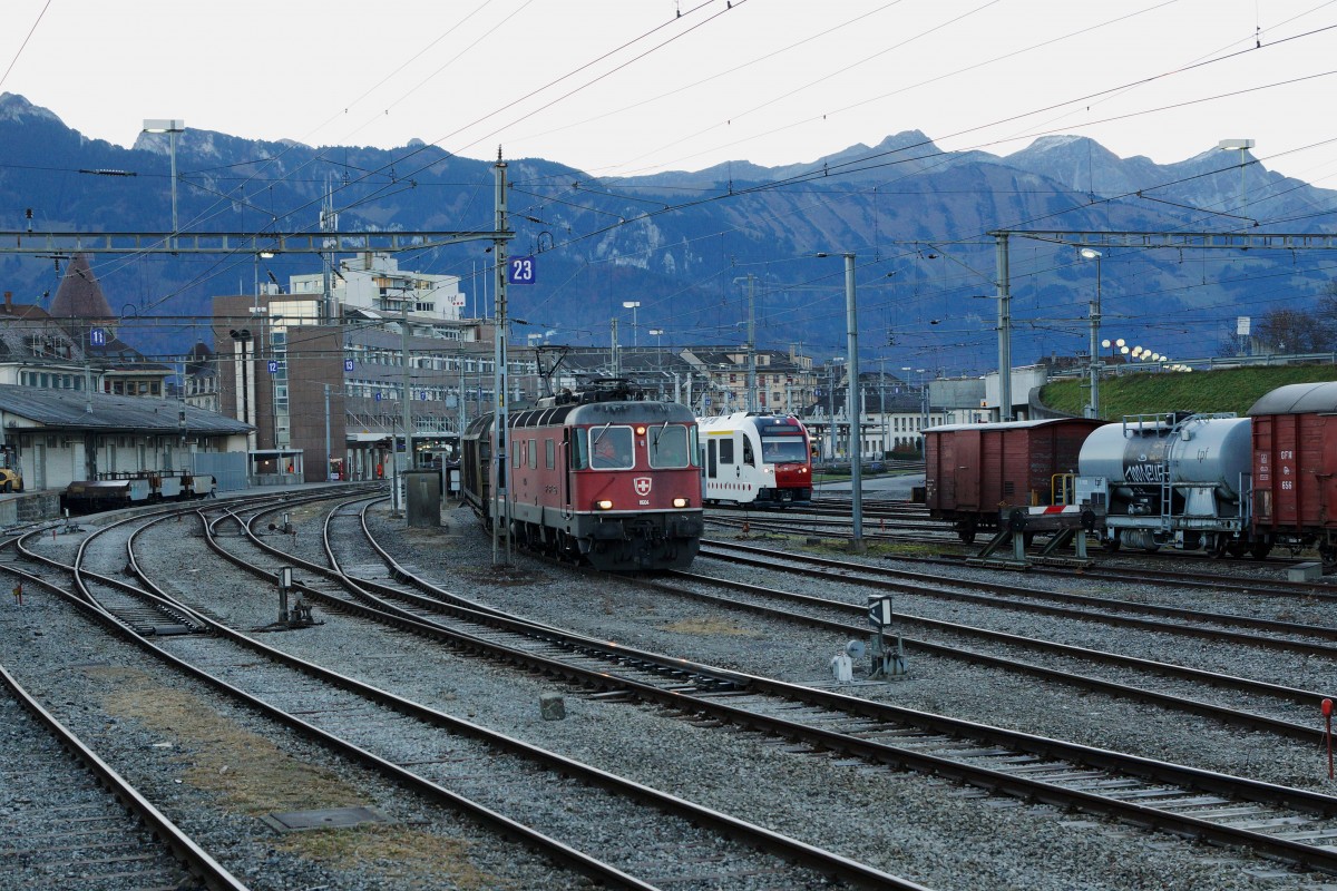 TPF/SBB: Morgendliche Herbststimmung in Bulle am 12. November 2015. Mit etwas Fotografenglück konnte der neue TPF Triebzug von Stadler Rail zusammen mit der Re 6/6 11604  FAIDO  verewigt werden. Bei der 11604 sowie der 11603 handelt es sich um Prototyplokomotiven, die im Jahre 1972 in Betrieb genommen wurden. Die 45 Serienlokomotiven  Re 6/6 11605-11649 bestellte die SBB im Jahre 1973. 
Foto: Walter Ruetsch 