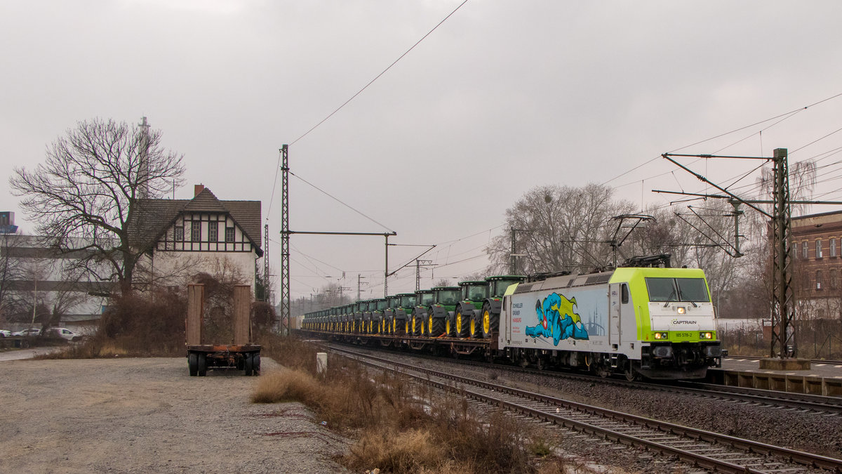 Traktoren??? Traktoren!!! Warum auch nicht, ergibt ein cooles Bild. 185 578-2 ist am 1. März 2019 mit einer langen Leine Traktoren unterwegs in Magdeburg-Sudenburg.  