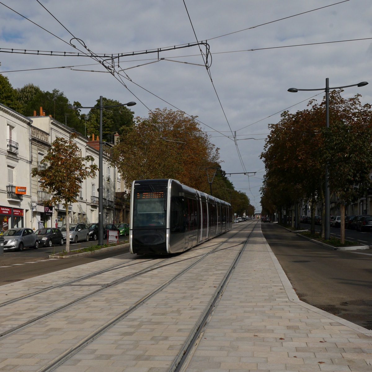 Tram FilBleu-055 fährt auf der Avenue de la Tranchée unter Fahrleitung zum Place-Choiseul, wo der Übergang zur unteridischen Stromversorgung mit dem System APS in der Innenstadt erfolgen wird.

2014-09-20 Tours
