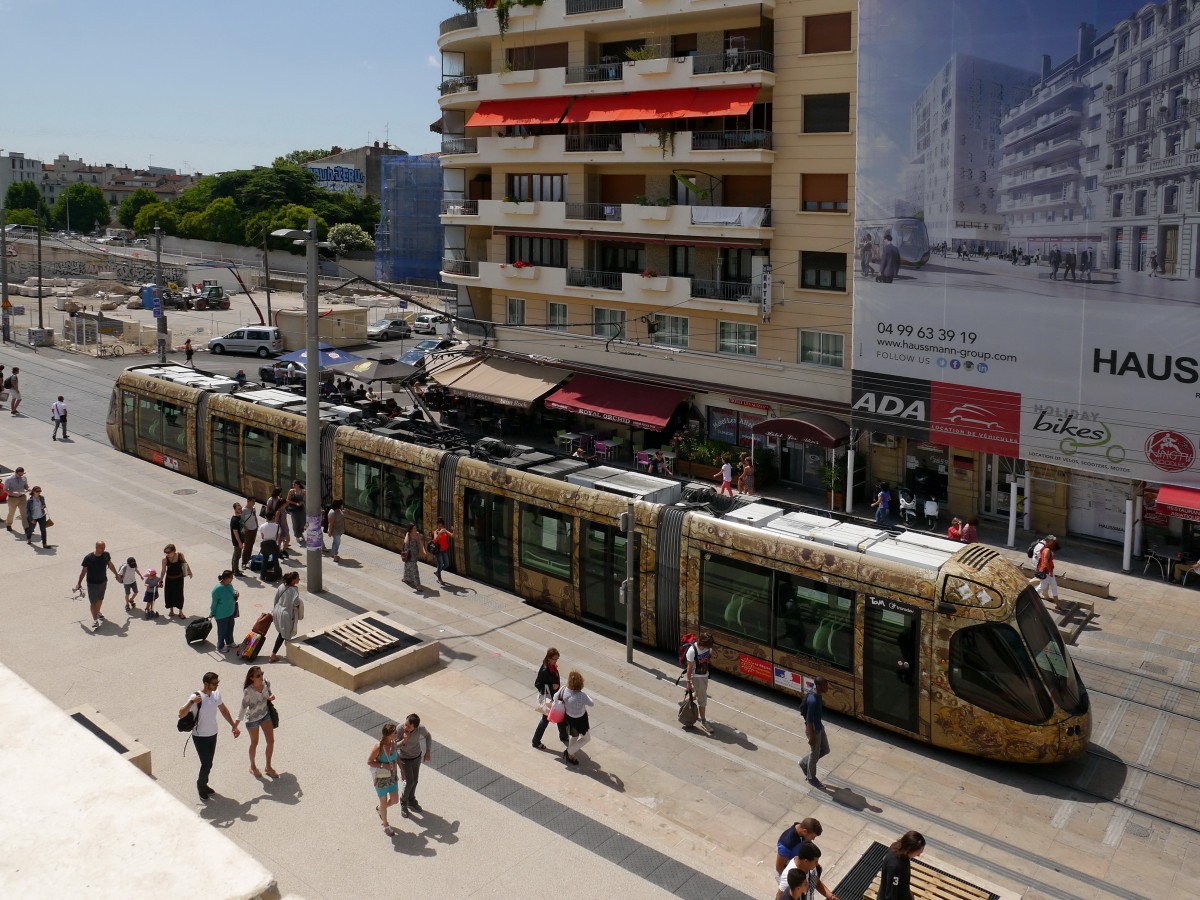 Tram TaM-2033'Jardin-du-Peyrou'(Citadis302 Alstom) unterwegs auf der Ligne 4 nach Saint-Denis. 
Die TaM (Transports de Montpellier Méditerranée Métropole)hat für jede der 4 existierenden Linien gesondert gestaltete Fahrzeuge im Einsatz. 

2015-05-30  Montpellier Gare-Saint-Roch 