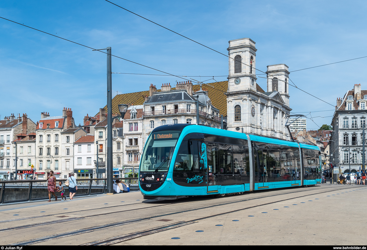 Tramway de Besançon: CAF Urbos 806 ist am 16. Juni 2017 auf der Linie 1 in Richtung Chalezeule unterwegs und befährt gerade die beim Bau der Tramlinie neugebaute Pont de Battant zwischen den Haltestellen Battant und Révolution. Im Hintergrund die Église Sainte-Madeleine. Die Fahrzeuge tragen alle Namen und Porträt einer berühmten Person aus der Region Franche-Comté.