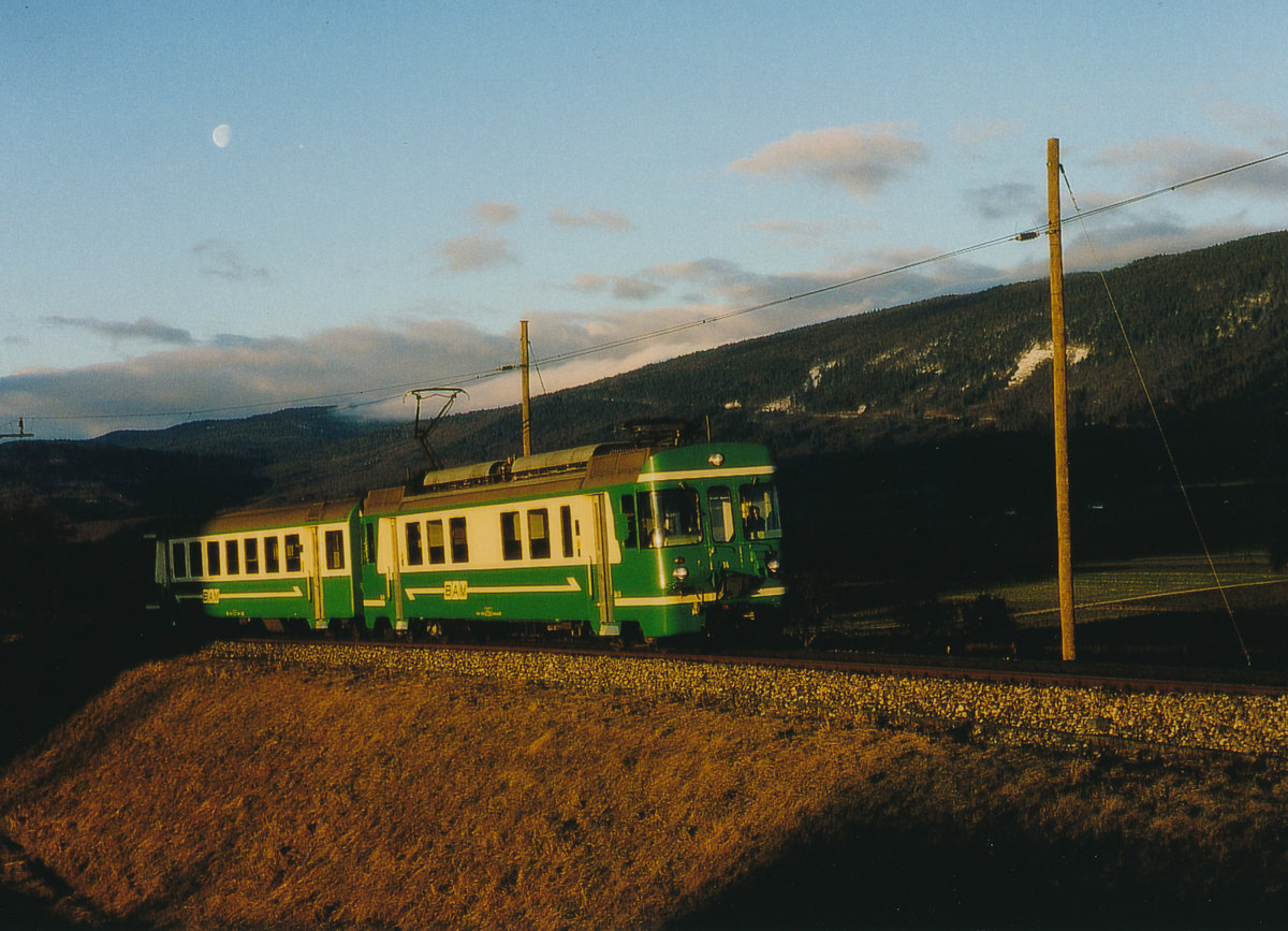 Transports de la région Morges-Bière-Cossonay, MBC/BAM.
Morgenstimmung bei Ballens an einem sehr kalten aber herrlichen  Morgen im Februar 1984.
Während sich am Himmel der Mond verabschiedet fährt der Regionalzug nach Morges mit dem Be 4/4 14  aus dem Schatten in die erste Morgensonne.
Foto: Walter Ruetsch

