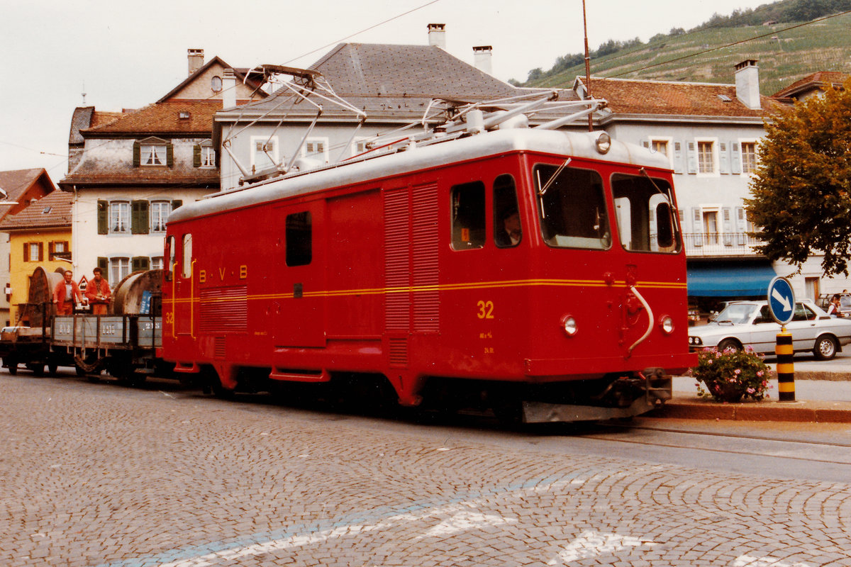 Transports publics du Chablais TPC/BVB. Abwechslungsreicher Bahnbetrieb bei der Bex-Villars Bretaye Bahn während den 80iger Jahren.
Bauzug mit drei Wagen beim Passieren des Place-du-Marché von Bex im Oktober 1982. Geführt wurde dieser nicht alltägliche Zug mit der HGe 4/4 32.
Foto: Walter Ruetsch 
    