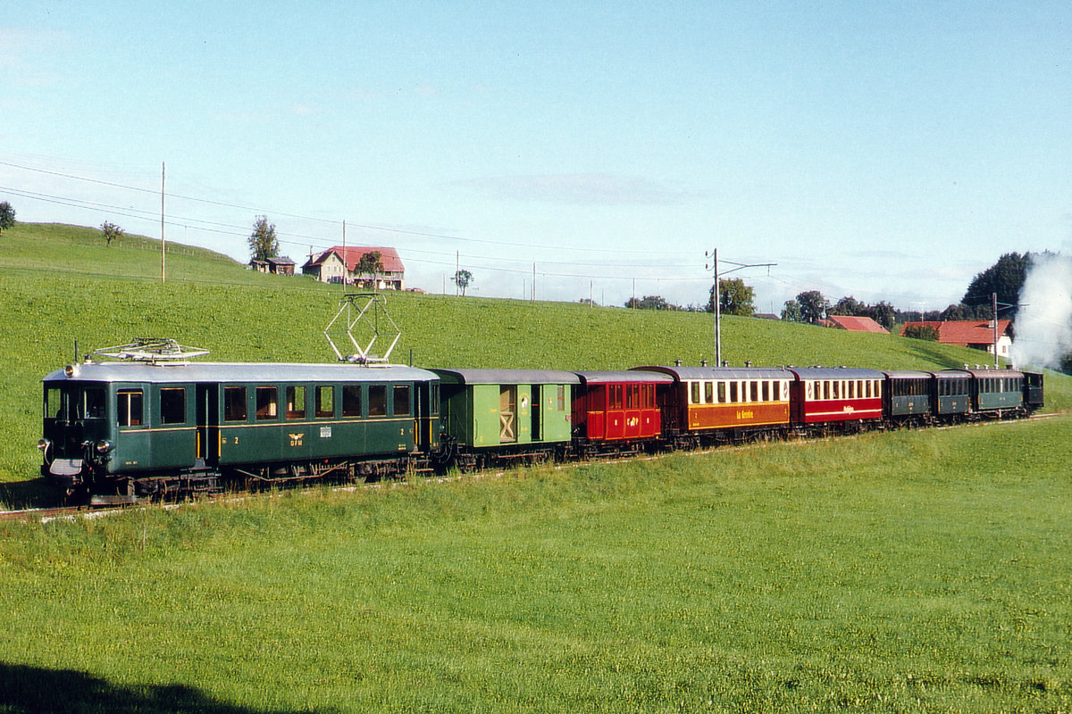 Transports publics fribourgeois/TPF/GFM.
Mit dem historischen Sonderzug von Bulle nach Saint-Légier.
Geführt wurde der ausserordentlich lange sowie sehr fotogene Zug im Juli 1993 vom GFM Be 4/4 121, der BC G 3/3 6, und Wagen von GFM und BC.
Der ehemalige ABe 4/4 121 mit Baujahr 1922 präsentierte sich damals noch im Zustand vor dem Umbau zum TPF Be 4/4 116.
Foto: Walter Ruetsch   