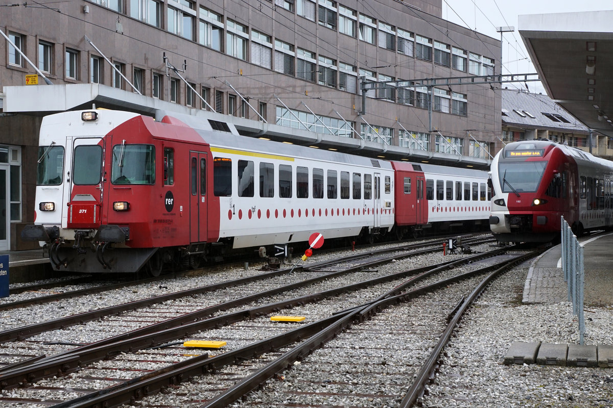 Transports publics fribourgeois/TPF.
Knotenpunkt Bulle, wo die Züge aus allen Richtungen der schmalen sowie der normalen Spur zusammentreffen.
Wie ich am 5. März 2020 an Ort und Stelle vernommen habe, verkehren auch im Jahre 2020 noch die Züge der normalen Spur nur bis zum Endbahnhof Bulle. Ab Bulle verkehren weiterhin die Züge der schmalen Spur als S 60 ab Voie 86 bis Broc-Fabrique.
Nach wie vor unentbehrlich sind die RBDe 537 171 bis RBDe 537 173 mit den passenden Steuerwagen sowie die Dreiwagenzüge mit BDe 4/4 121 bis BDe 4/4 124.
Foto: Walter Ruetsch 