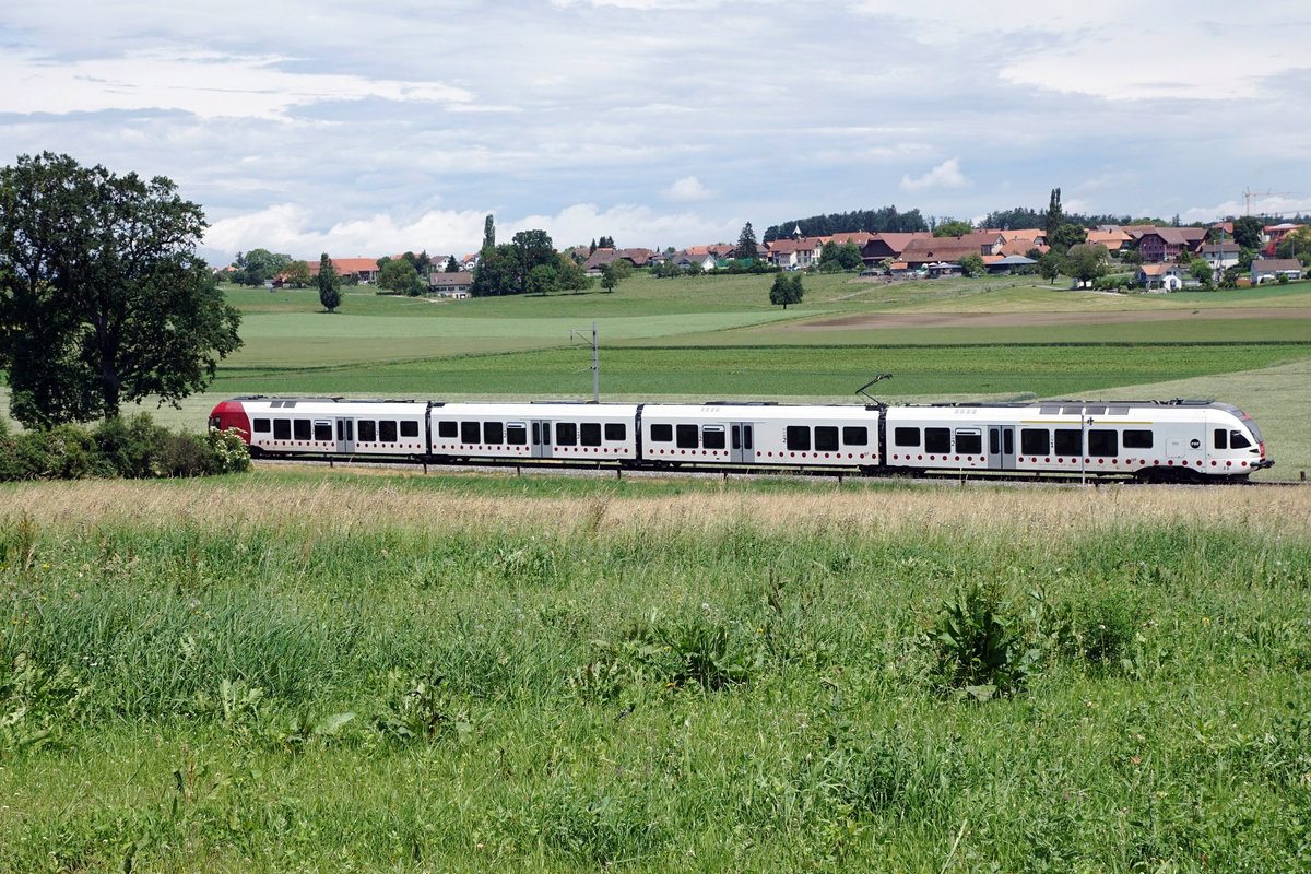 Transports publics fribourgeois/TPF.
RABe 527 Flirt als S 20 bei Cressier unterwegs vor der Kulisse der ländlichen Gemeinde Salvenach, ab dem 1. Januar 2016 Ortsteil von Murten.
Foto: Walter Ruetsch
