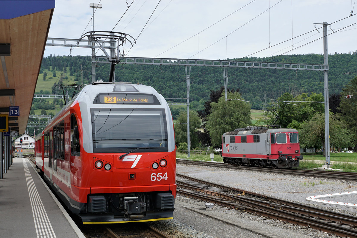 TRAVYS:
AUSSERHALB DER HEIMISCHEN GELEISEN.
Begegnung zwischen der TRAVYS Re 4/4 II 420 503-6 ehemals BLS, ehemals SBB und dem CJ Be 4/4 654 in Glovelier am 6. Juni 2018.
Foto: Walter Ruetsch