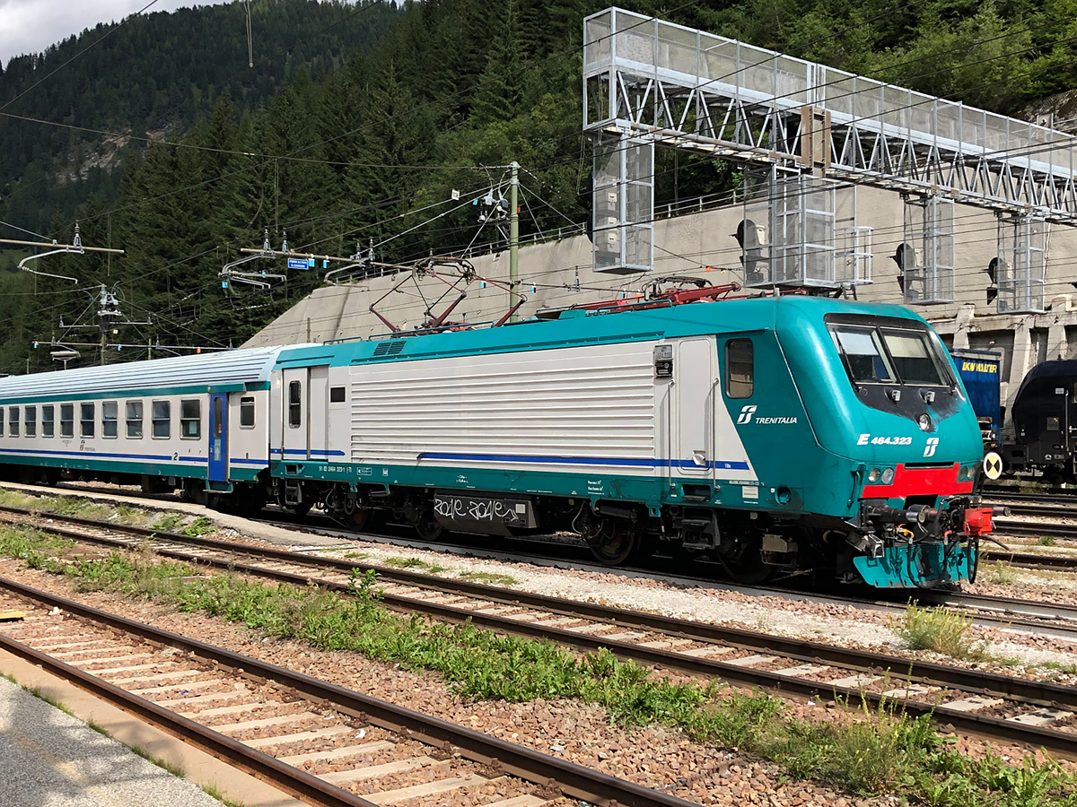 Trenitalia E464 323 zieht einen Regionalzug nach Bologna Centrale. Hier bei der Ausfahrt aus dem Bahnhof Brenner/Brennero. Aufgenommen am 23.08.2021