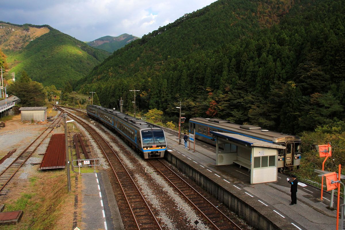 Triebwagen 1022 im Lokalverkehr auf der Insel Shikoku wird vom Inrercity-Express 2009 berholt; der Wagenfhrer des Lokalzugs grsst den Intercity. Aufnahme in Shiget auf der Passhhe zwischen Nord- und Sd-Shikoku, 4.November 2017. 