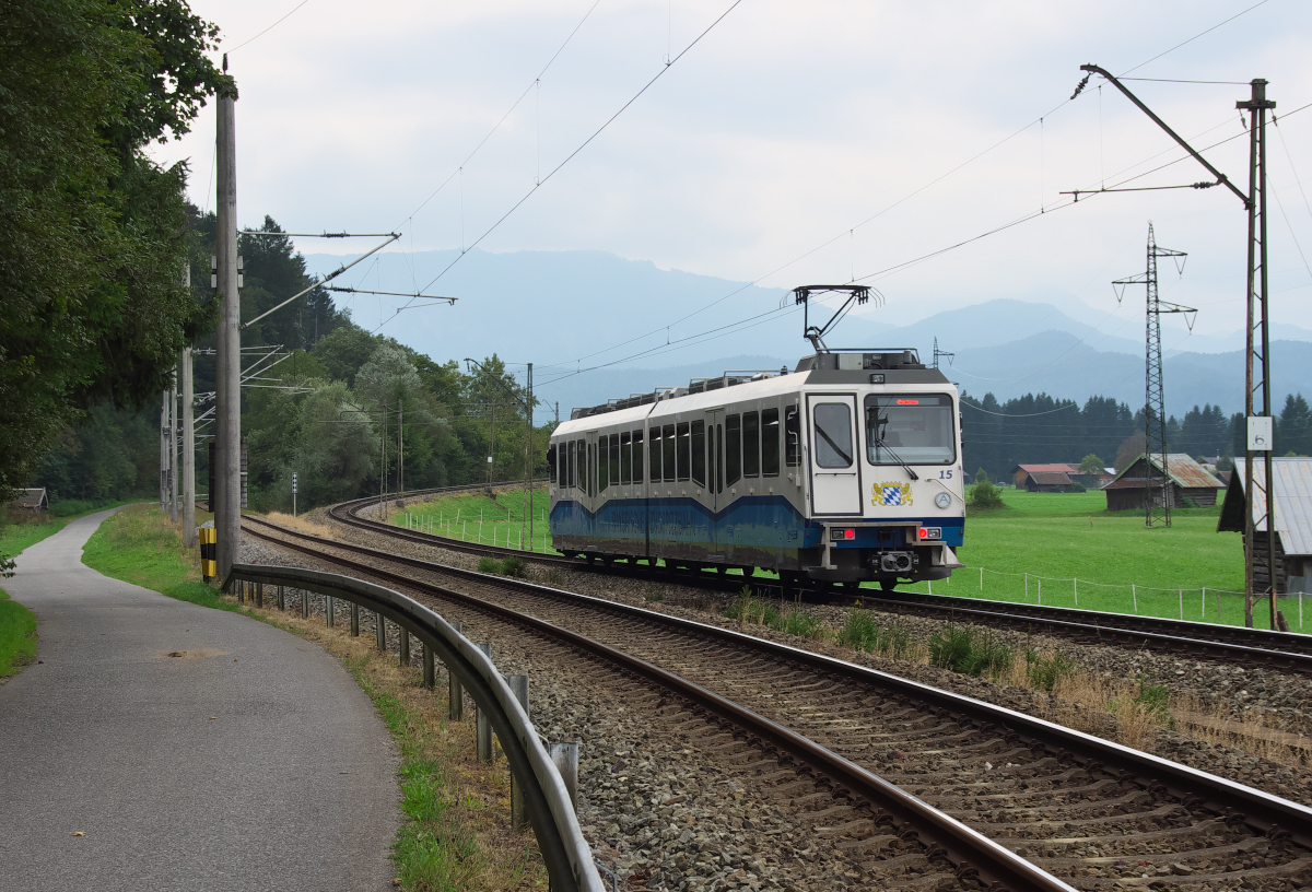 Triebwagen 15 der Bayerischen Zugspitzbahn ist auf dem Abschnitt ohne Zahnstange zwischen Garmisch und Grainau unterwegs, hier bei Km 2,6. Die Strecke steigt gleich an und wird bei Km 3 die Außerfernbahn nach Reutte in einer Linkskurve überqueren. 16.09.2016