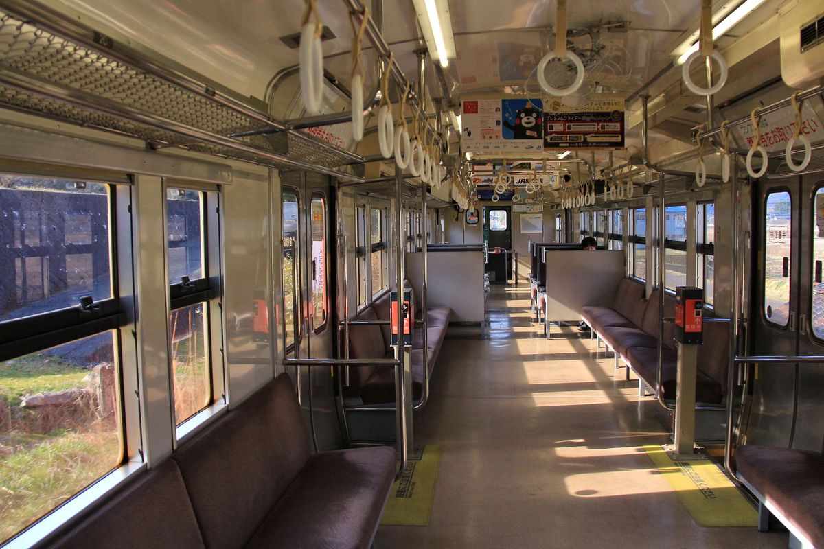 Triebwagen KIHA 47 3501 vermittelt noch die schlichte Atmosphäre der alten Staatsbahn, bereit für viele und auch stehende Passagiere. Die Sitzgruppen und Längsbänke sind einfach und eher unbequem. Neben den Türen stehen die kleinen Ausgabekästen für die Zettel, auf denen jeweils die Nummer des Einsteigeorts steht; wenn der Zug einmännig geführt wird, wirft man beim Aussteigen das Fahrgeld zusammen mit dem kleinen Zettel unter den Augen des Wagenführers in den Kasten - eine Leuchttafel zeigt an, wieviel die Fahrt je nach Nummer auf dem Zettel kostet. Selbstverständlich kann man im Kasten auch Geld wechseln. Die KIHA 47 gehören zu den wenigen Wagen, wo sich die Fenster noch öffnen lassen; bei neueren Wagen ist es völlig unmöglich, Aufnahmen ohne störende Spiegelungen (und damit auch Ablehnung durch den Admin.!) zu machen. 26.März 2017.  