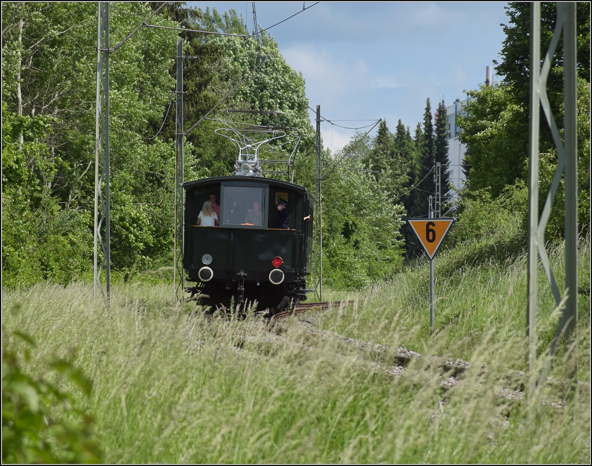 Triebwagen Zeug Christe der Trossinger Eisenbahn mit beachtenswerten Strommasten, die vermutlich noch Überlebende aus dem 19. Jahrhundert sind. Trossingen, Juni 2022.