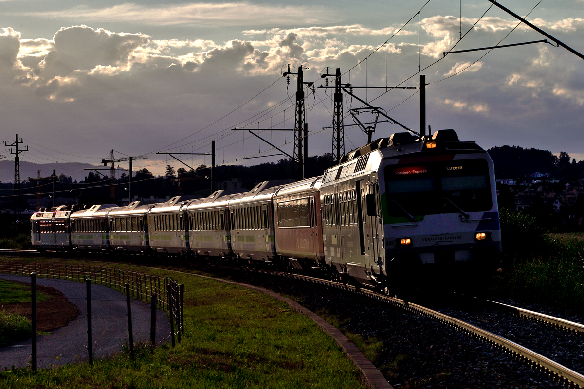 Triebzug RBDe 561 082 mit EW 1 Bodan 1.Klasse Wagen braust im Gegenlicht in Bollingen vorüber.Bild vom 27.7.2015