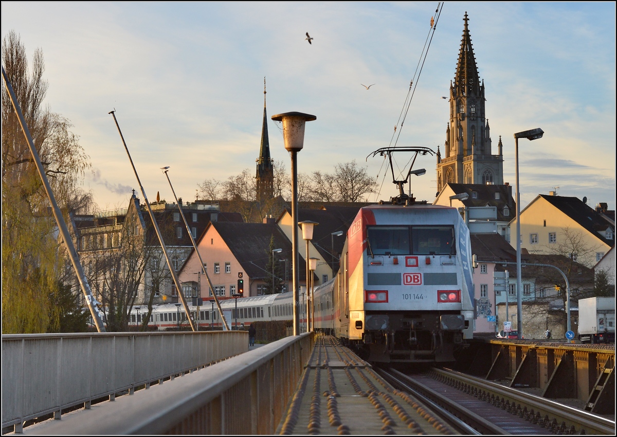 Trotz des Ende des Fernverkehrs am See bleibt wenigstens am Wochenende noch der Spielzeug-IC 2005 Bodensee, gut für den Bahnfotografen. Zuglok 101 144 mit der Herta-Werbung läuft bei der Bereitstellung noch am Zugschluss. Die föhnige Stimmung sorgt für ein interessantes Licht.