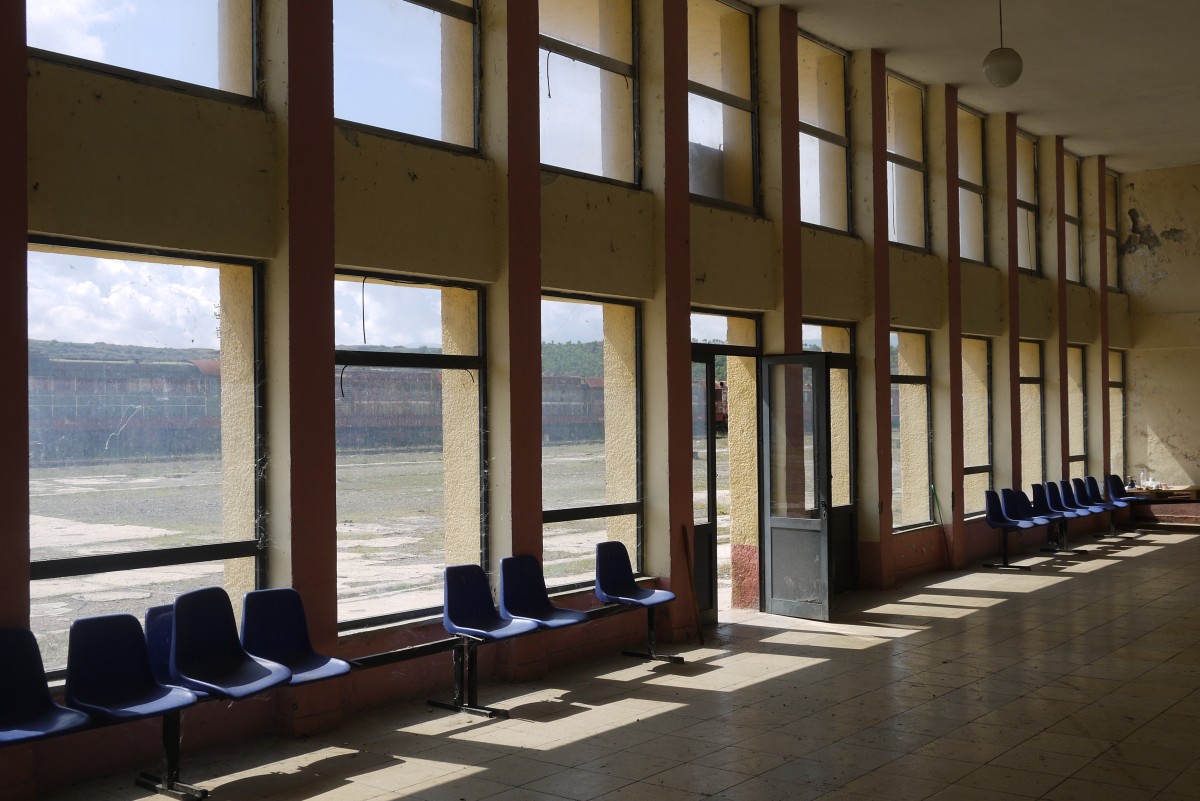 Trotz jahrelanger Betriebsruhe wirkt der Bahnhof Prrenjas sehr gepflegt. Durch die Glasfront kann man den  Lokfriedhof  in Gleis 3 und 4 ahnen (8.9.14).