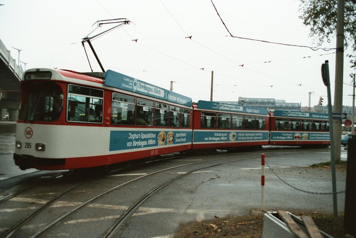 TW 205 der Freiburger Straßenbahn auf einem ca. 200 m langen Verbindungsgleis zwischen den Haltestellen Hauptbahnhof und Stadttheater. Im Hintergrund ist schon die neue Stadtbahnbrücke, welche im Dezember 1983 eingeweiht wurde.  Lt. wikipedia zählt TW 205 zum Typ GT8K, und ist noch erhalten.  
Datum: 29.10.1983