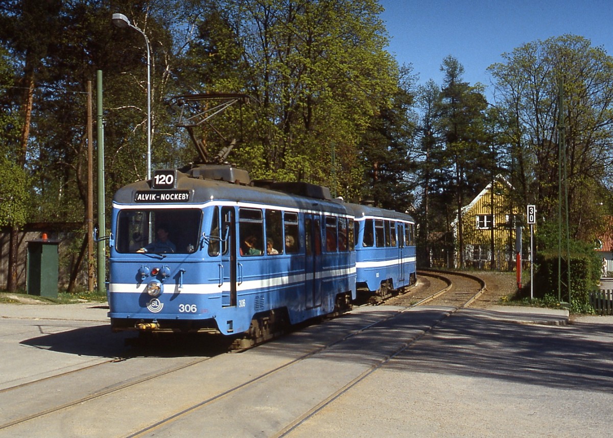 Tw 306 der Nockebybahn mit Steuerwagen ist Mitte Mai 1988 zwischen Alvik und Nockeby unterwegs. Die Bahn verläuft durchgehend zweigleisig auf eigenem Bahnkörper.