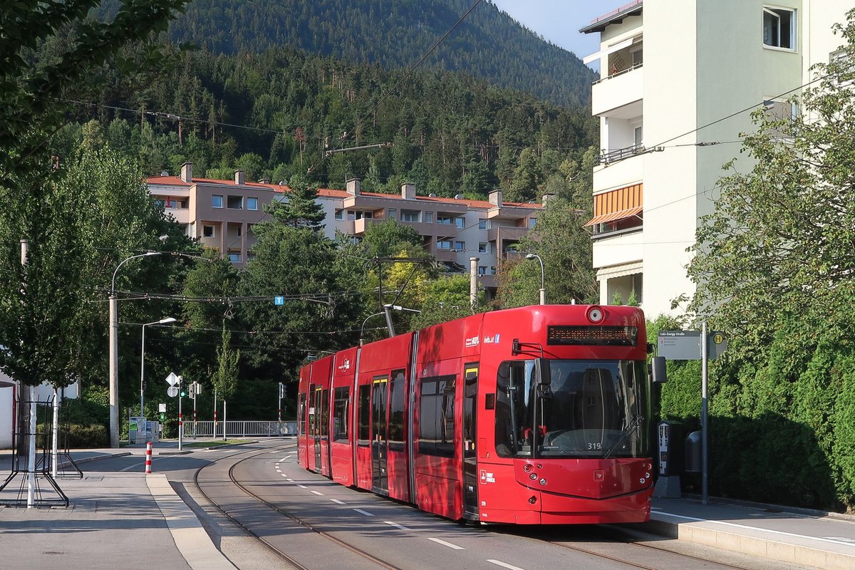 Tw. 319 als Linie 3 der Innsbrucker Verkehrsbetriebe an der Haltestelle Luis-Zuegg-Straße mit Ziel Peerhofsiedlung (der Häuserblock im Hintergrund). Die Westäste zur Peerhofsiedlung und nach Technik-West wurden am 10.12.2017 eröffnet und bis voraussichtlich Dezember 2018 von der Linie 3 bedient, danach soll die neue West-Ost-Durchmesserlinie 2 diese Strecken befahren. Aufgenommen 24.7.2018.