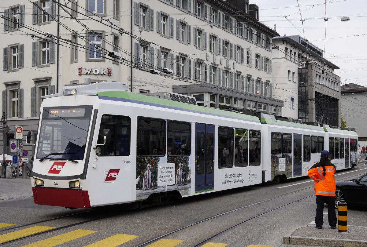 Tw 34 der Appenzeller Bahn im innerstädtischen Streckenabschnitt der S 21 in St. Gallen (30.4.16). Die Polizistin erwartet den Demonstrationszug am Vortag des 1. Mai. Der größte Teil der Oberleitung gehört zum städtischen Obis-System.