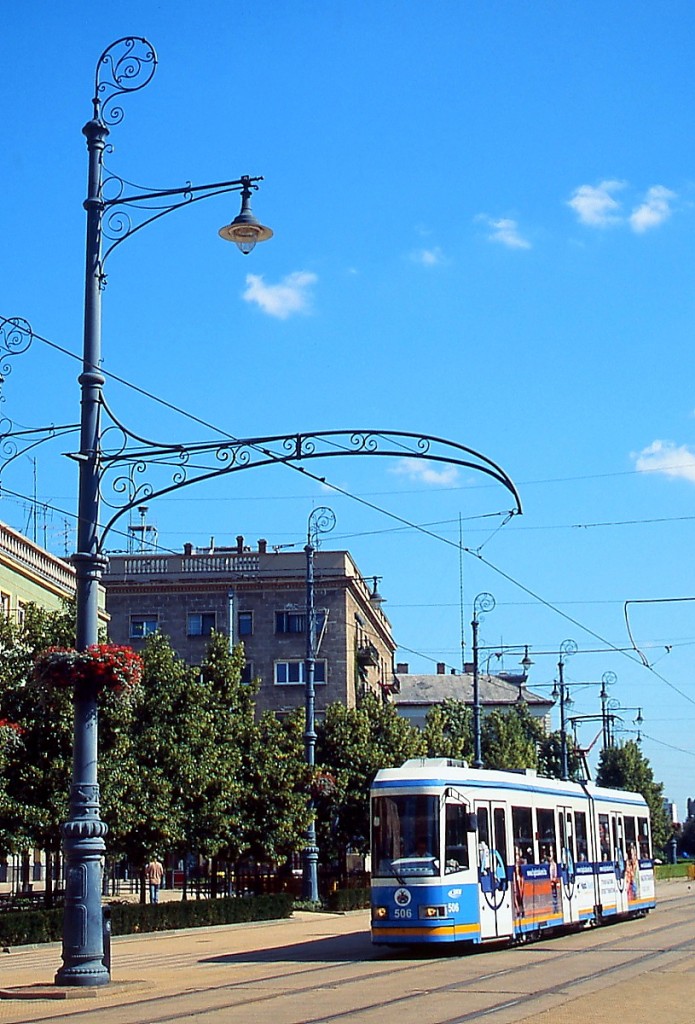 Tw 506 der Straßenbahn Debrecen am 13.06.2011 am Kossuth ter. Beachtenswert die imposanten, aber dennoch filigranen Oberleitungsmasten, die sich der historischen Bebauung der Innenstadt anpassen.