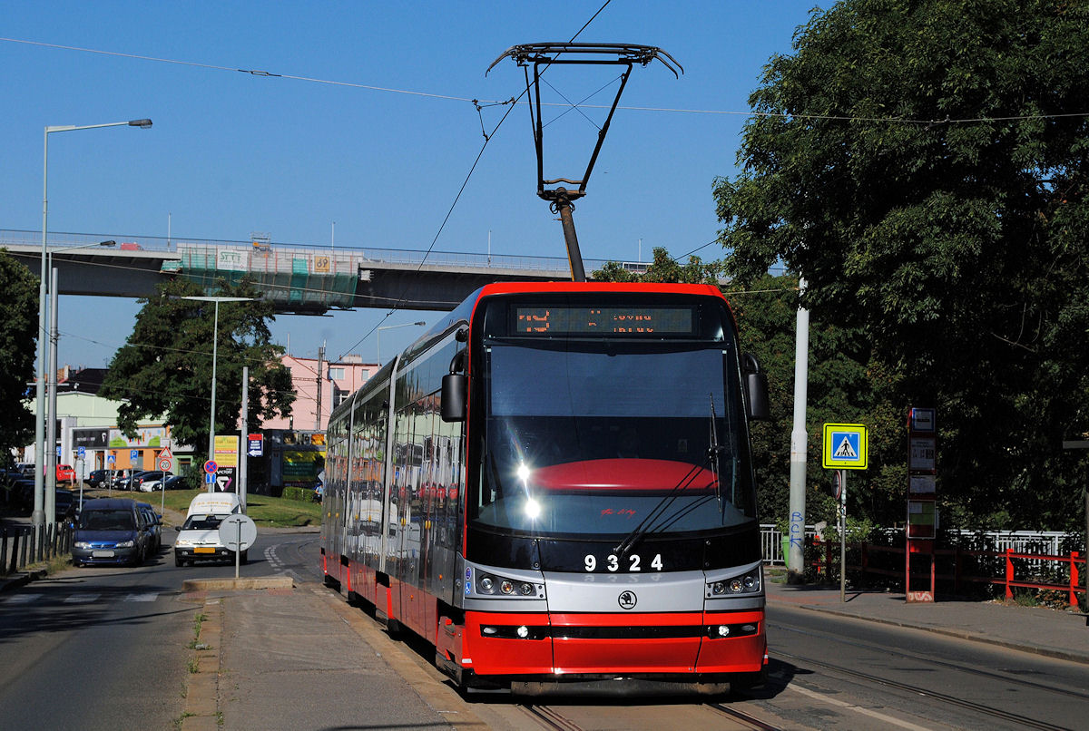 Tw. 9324 der Linie 18 erreicht die in der Kresemyslova gelegene Haltestelle Divadlo na Fidlovacce, im Hintergrund erkennt man die über das Nusletal führende Schnellstraßenbrücke, in deren Inneren auch die Trasse der Metro untergebracht ist. (26.08.2016)