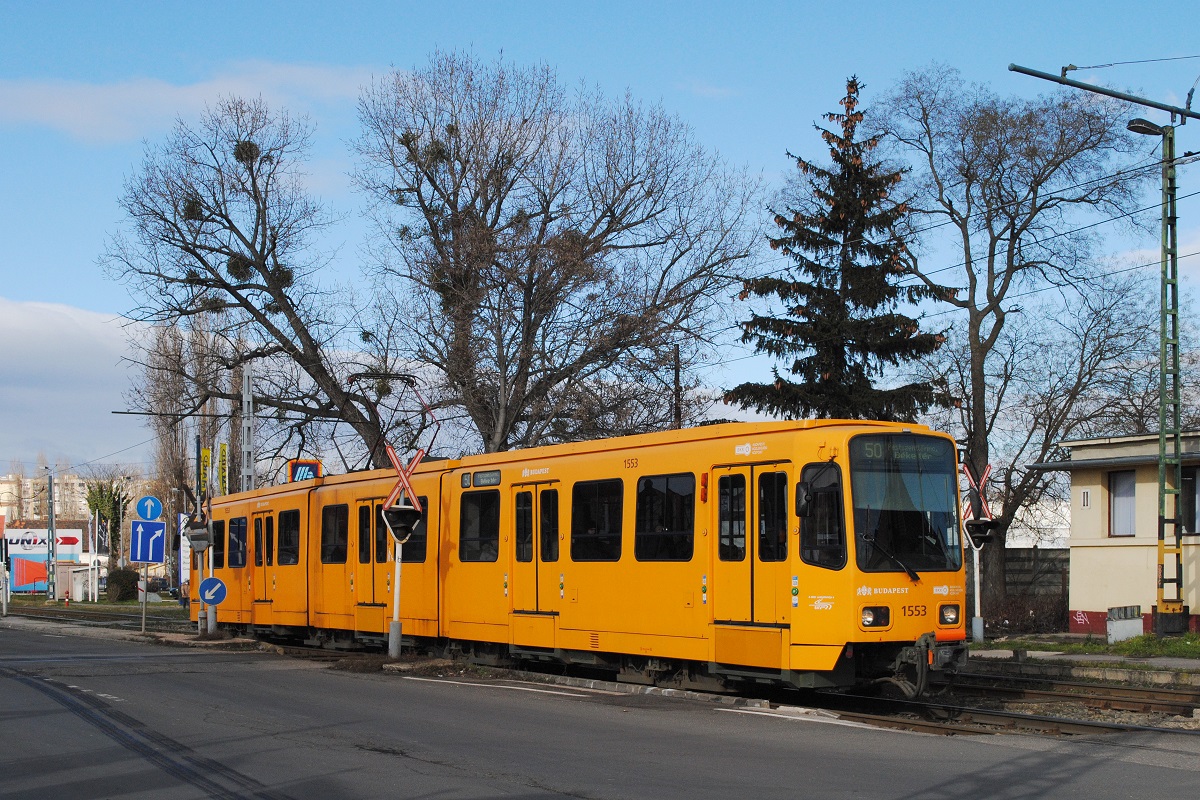 Tw.1553 überquert als Linie 50 in der Üllöi ut die Bahnübersetzung im Bereich des Bhf. Kispest. (02.02.2023)