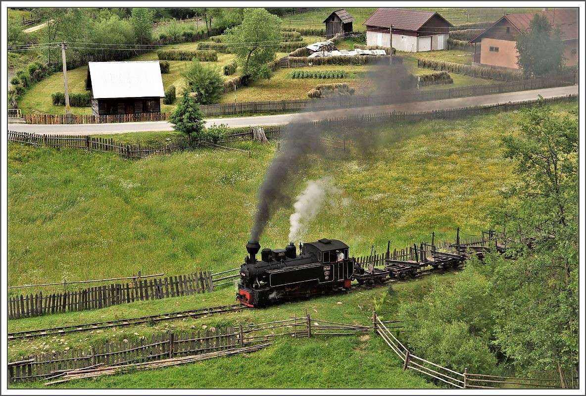 Typisch für das ländliche Rumänien im Karpatenbogen werden Felder und Bahntrassen durch Holzzäune begrenzt. Auch 764.404R zwischen Moldovita und Argel fährt einen ZickZack Kurs zwischen den Holzzäunen. (14.06.2017)
