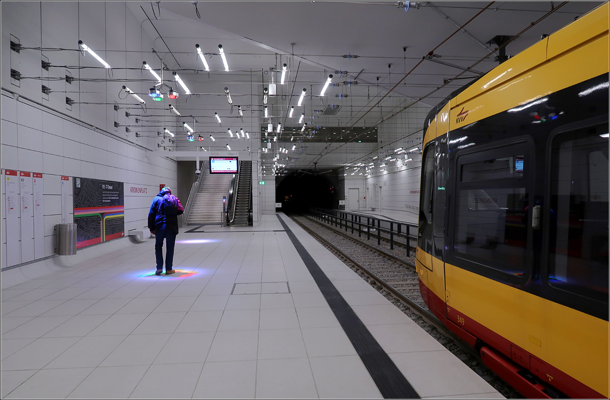 U-Haltestelle Kronenplatz Karlsruhe -

Zwischen den hellen Leuchtstoffröhren sind immer wieder drei mehrfarbige runde Strahler aufgehängt die farbiges Licht auf den Boden werfen. Interessant wird es wenn ein Reisender sich unter diese Lichtquelle stellt und selber bunt erscheint und ein Farbenspiel auf dem Boden entsteht.

12.01.2022 (M)