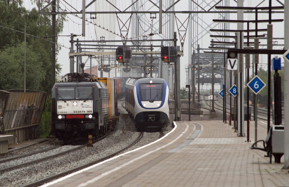 Über die Brücke bei Zwijndrecht in die Nähe von Rotterdam und Kijfhoek gehen ein Güter-Zug und ein SLT Person-Zug zu gleich den Bahnhof hinein. 07-08-2013.