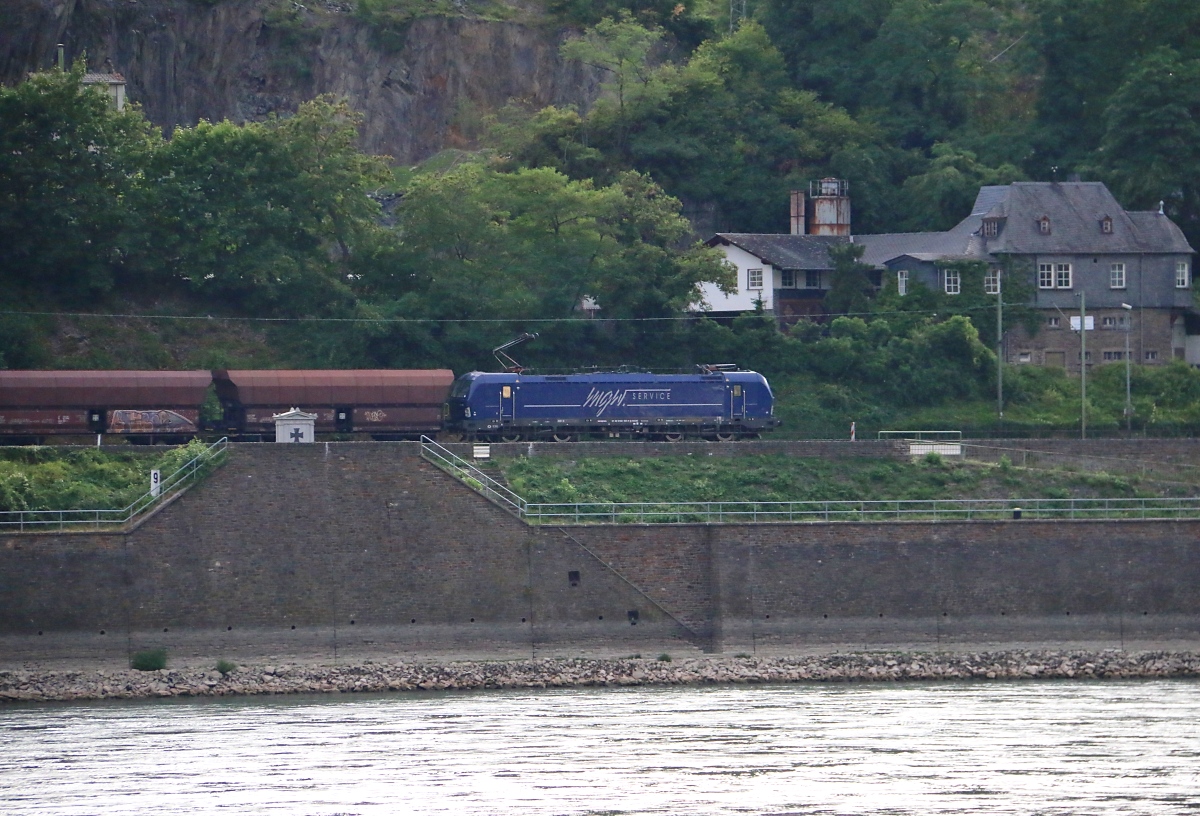Über den Rhein geschaut: eine Vectron der MGW bespannt einen Schüttgutwagen-Ganzzug in Fahrtrichtung Koblenz. Aufgenommen am 14.07.2015 von Kaub am Rhein aus.