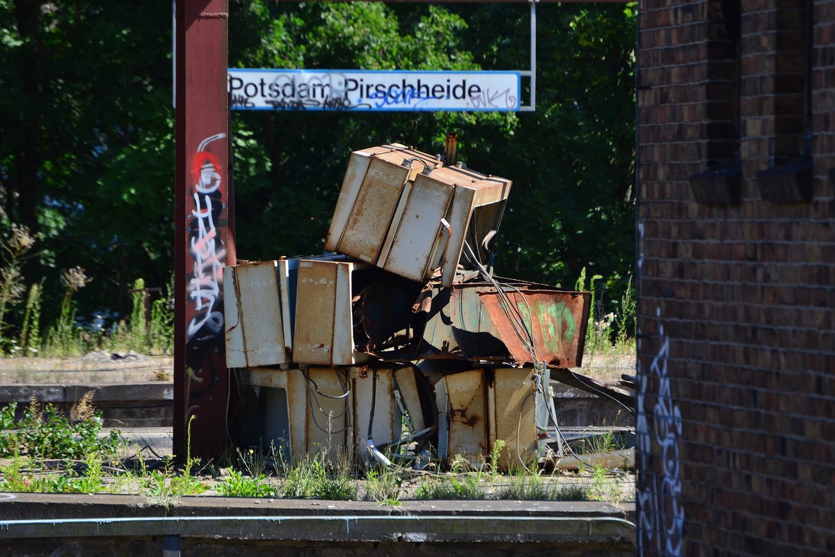 Über viele Jahre nach der Schließung der oberen Bahnsteige in Potsdam Pirschheide hingen dort noch die alten Fallblattanzeiger. Am 23.7.18 waren sie schon als Schrott gestapelt. 

Potsdam Pirschheide 23.07.2018