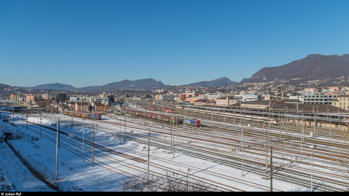 Überblick über den Bahnhof Chiasso. Links Abstellanlagen für Güterzüge und Güterzugloks, dazwischen auf einem Damm die Doppelspur zum Güterbahnhof Smistamento, rechts der Personenbahnhof mit einem abgestellten ICN (der wohl am Abend nach Zürich fährt). In der Mitte hinten die Ausfahrt in Richtung Balerna. Aufnahme vom 24. Januar 2017.