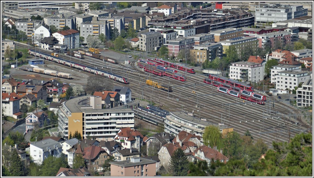 Überblick über den Güterbahnhof Chur mit den Abstellgleisen für SBB im Vordergrund und die Schmalspurgeleise der RhB im Hintergrund. Viele Panoramwagen des Glacier- und Berninaexpress sowie zwei Ffabrikneue Capricorn stehen auf den RhB Geleisen, während auf der SBB Seite zwei Twindexx und zwei Kiss, sowie einige Bcm abgestellt sind. (12.04.2020) Aufnahmen von der Nassen Platte.