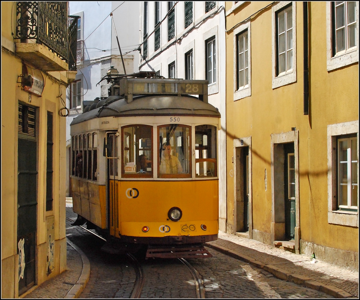 <U>Heiße Gleise.</U>

Heute ist die Kneipe links im Bild leider geschlossen. Früher trug einen der Schwung beim Aussteigen bis direkt vor den Tresen. Alfama, Lissabon im September 2010.