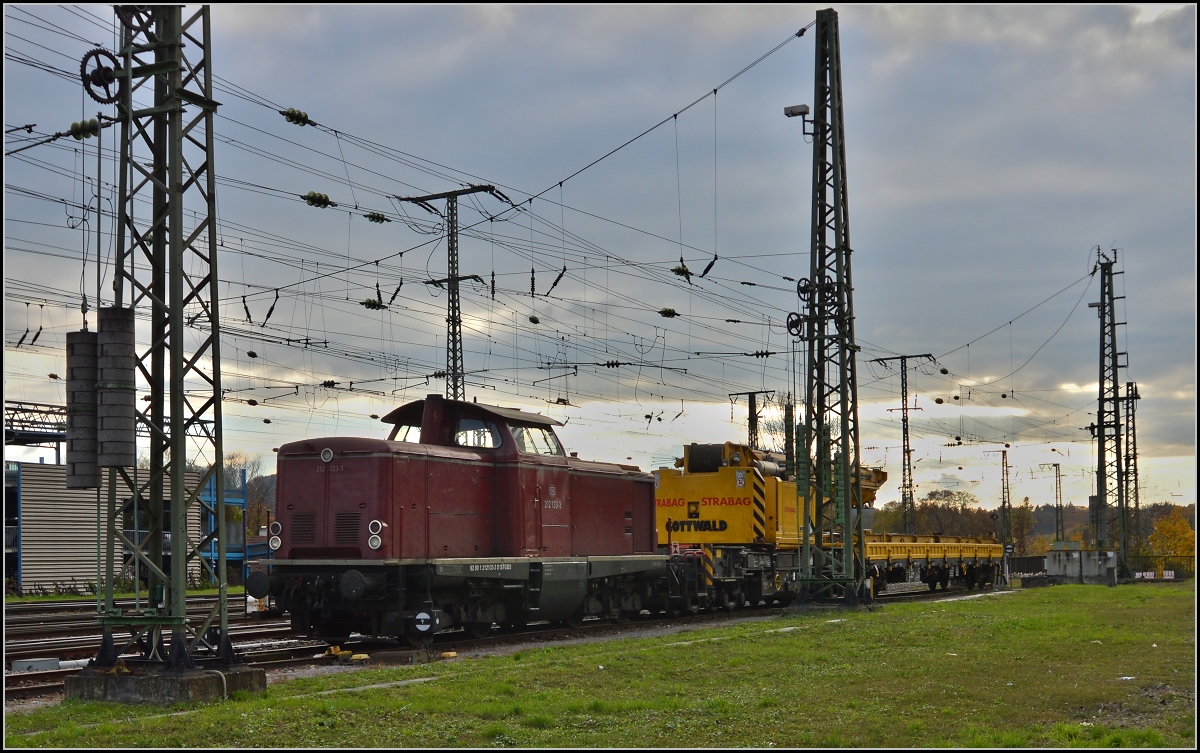 <U>Lichtspiele in Singen am Hohentwiel.</U> 

212 133-3 vor aufklarendem Himmel. Nach einem Rangierunfall mit einigen Güterwägen hatte die Lok die  Aufgleishilfe  nach Singen gebracht. November 2013.