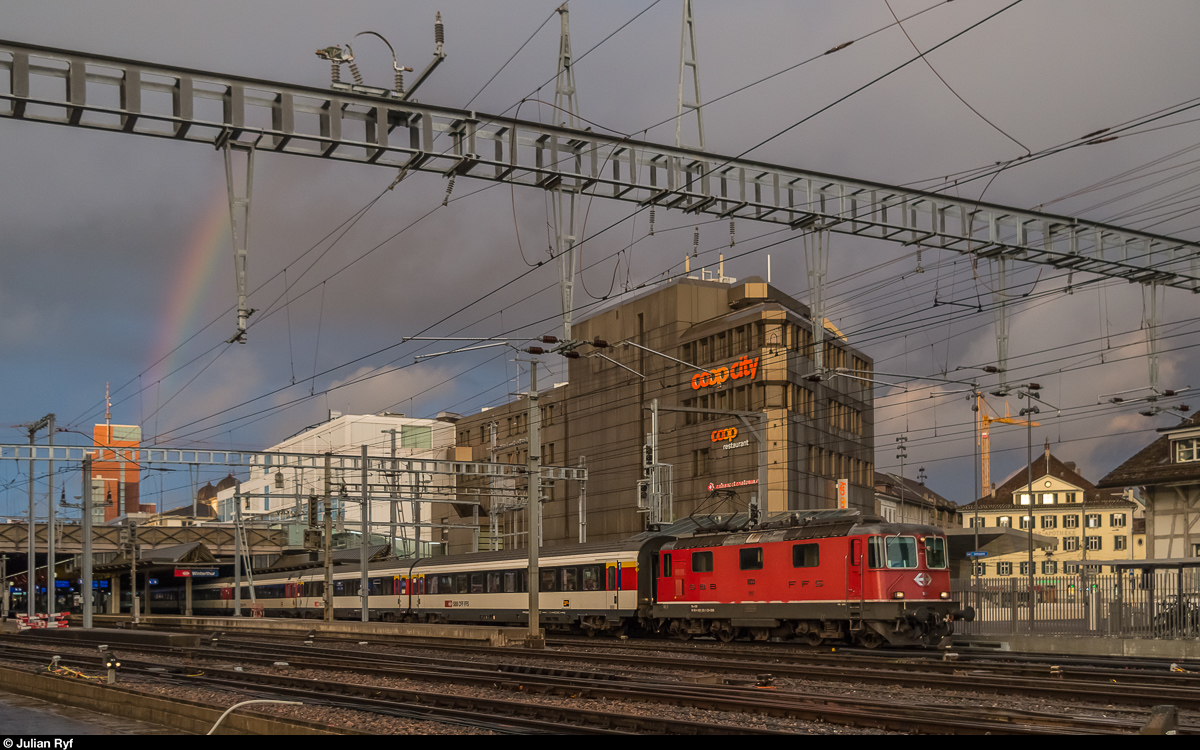 Um 18:28 Uhr, als der IR St. Gallen - Zürich mit ex-Swiss-Express Re 4/4 II 11133 am 9. Oktober 2016 den Bahnhof Winterthur verliess, war die Sonne leider bereits fast vollständig hinter dem Horizont verschwunden. Einzig die Spitze des Roten Turms ist noch beleuchtet - und der Himmel, an dem sich direkt über dem Turm ein Regenbogen zeigt.