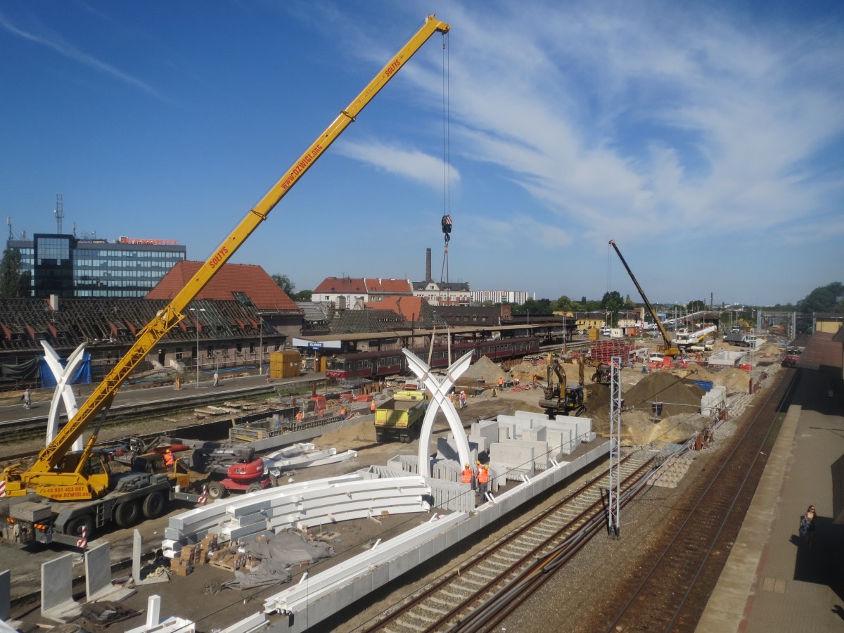 Umbau bzw. Renovierung vom Hauptbahnhof Gleiwitz (Gliwice) schreiten voran. Am 2. Juli 2015 wurde mit der Aufstellung der Säulen für die neue Bahnhofshalle begonnen. Foto von der provisorischen Bahnüberführung zwischen den Bahnsteigen.