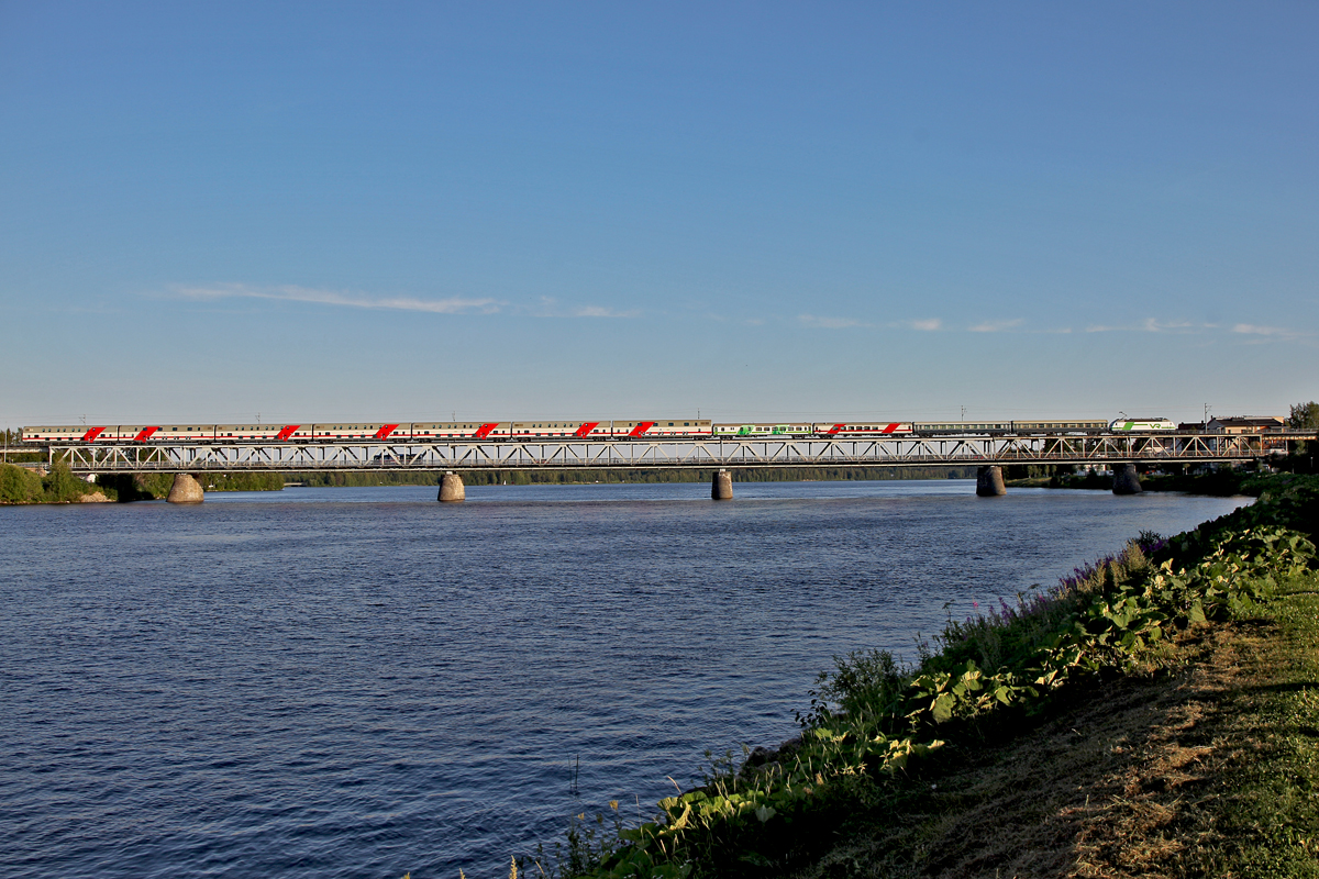 Unbekannte Lok der Vr Baureihe Sr1 rollt mit dem Pikajuna P 274 aus Kemijärvi kommend nach Helsinki über die Eisenbahnbrücke in Rovaniemi am 21.7.2014