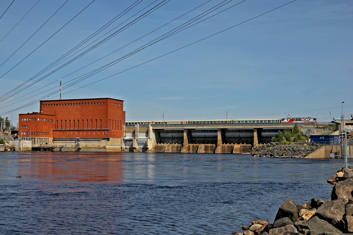 Unbekannte Vr Lok Sr 1 überfährt die Passage beim Flusskraftwerk Isohaara bei Kemi mit dem Pikajuna P 710 nach Kuopio am 22.7.2014