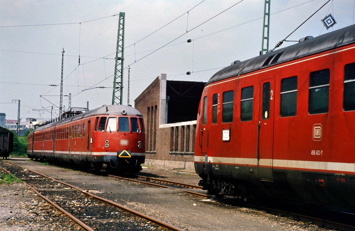 Und wieder das Bahnbetriebswerk Heidelberg, eine lebendige Ruine: Zwei Züge der DB-Baureihe 456 (ET 56) waren dort zu finden. 456 107-2, 856 007-0, 456 407-6 und rechts daneben 456 402-7. 
Wer die Ruine noch erforschen will, es ist noch einige Zeit dafür vorhanden, bis das Areal von Baufirmen bearbeitet werden soll.
Datum: 16.05.1985 