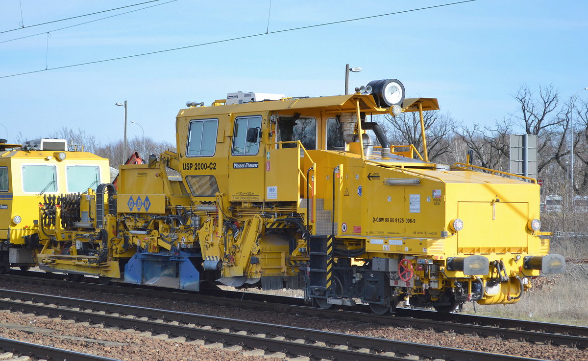 Universalschotterplaniermaschine USP 2000-C2 vom Hersteller Plasser & Theurer der Fa. GBW (D-GBW 99 80 9125 008-9) am Haken einer Gleisstopfmaschine der Fa. GBW am 06.03.19 Bf. Flughafen Berlin-Schönefeld.
