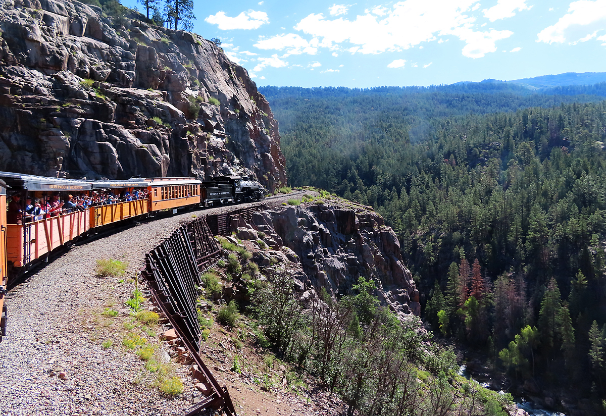 Unser Dampfzug von Durango nach Silverton nähert sich im San Juan National Forest der imposanten und berühmtesten Stelle am felsigen Abgrund. Beeindruckend die Linienführung in dieser gebirgigen Landschaft!  Durango - Silverton, CO, 1.9.2022