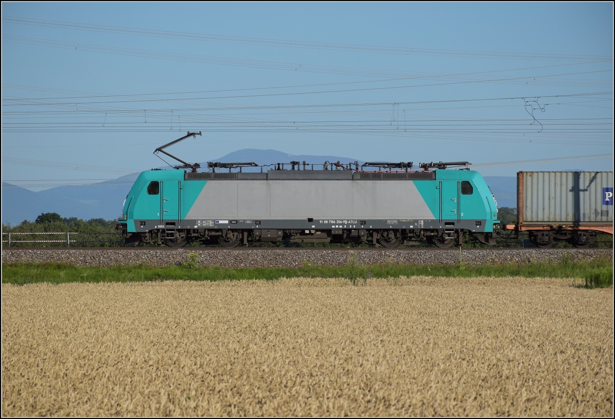 Unter dem gestrengen Blick des Osterhasen... 

Die Belgierin 186 206 ist bei Auggen sdwrts unterwegs whrend der Blick bis ins Elsass reicht. ber der Lok erhebt sich das groe Belchen. Juli 2020.
